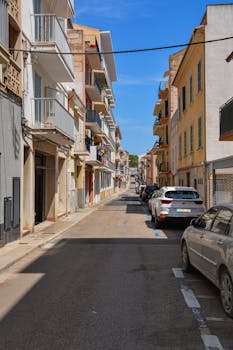 Idyllic street view in Mallorca with parked cars and traditional buildings.