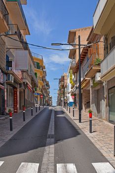 A picturesque street in Mallorca with colorful buildings under a bright blue sky.