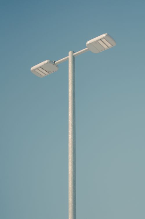 Free A minimalist street lamp set against a clear blue sky, emphasizing simplicity and modern design. Stock Photo
