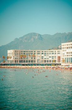 A sunny day at a Mediterranean resort with people enjoying the sea.