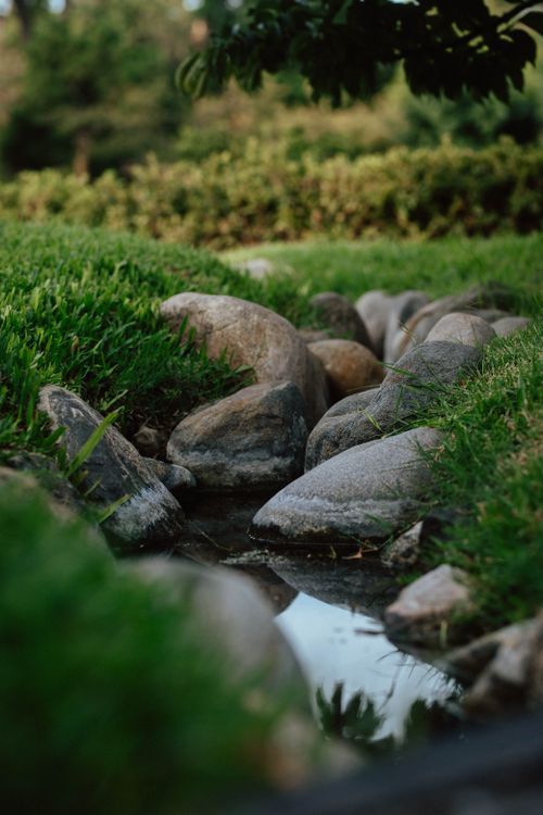 Free Serene Japanese stone garden with stream reflecting nature at a Buenos Aires park. Stock Photo
