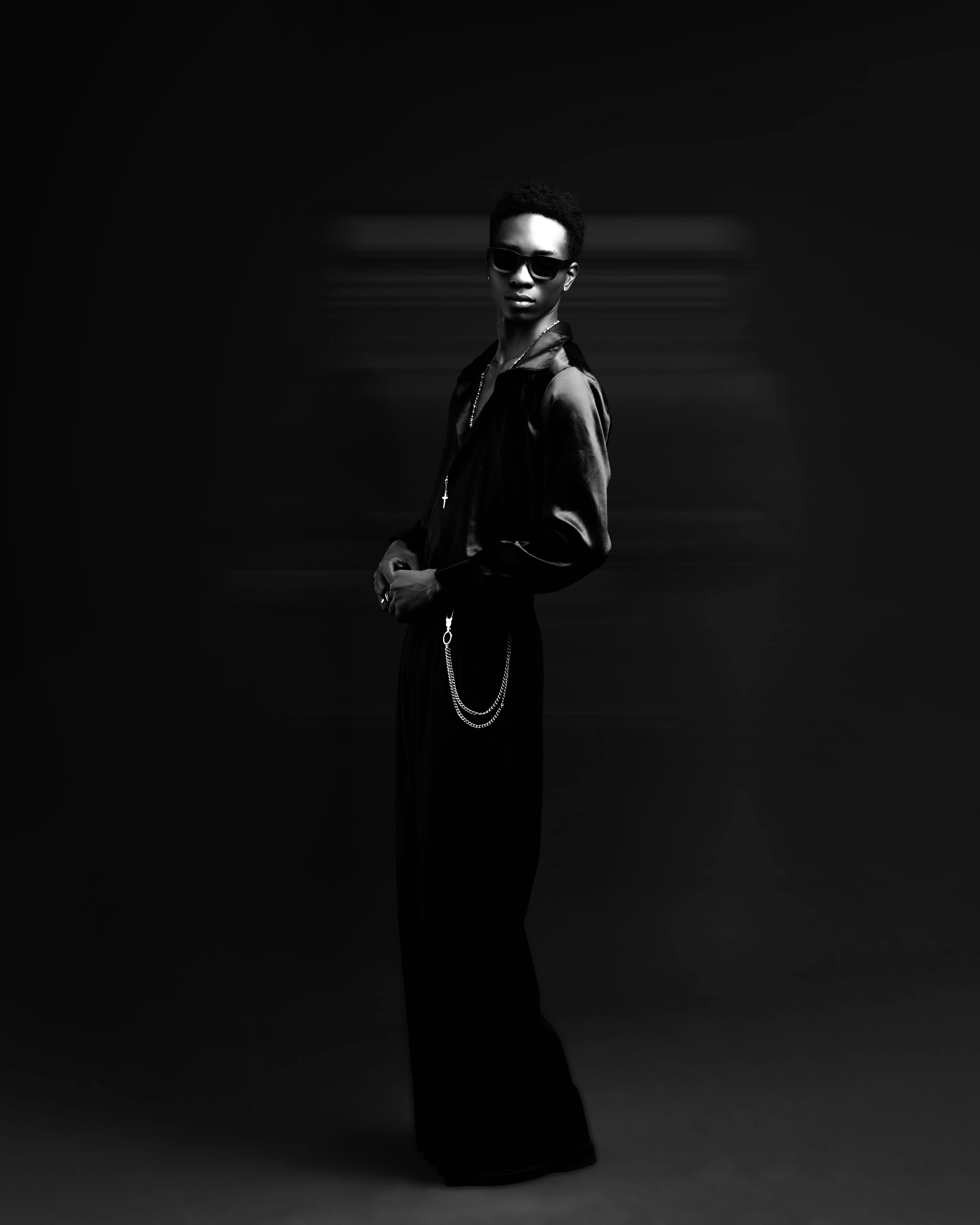 Artistic black and white portrait of a stylish individual wearing sunglasses.