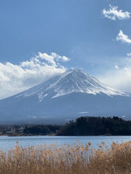Stunning winter view of snow-capped Mount Fuji across the lake under a bright sky.