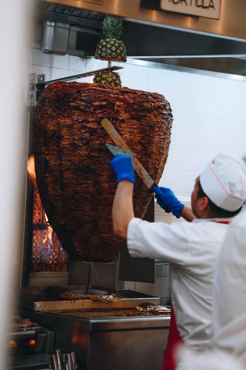 Free A chef expertly slices a large al pastor shawarma in a New York City kitchen. Stock Photo