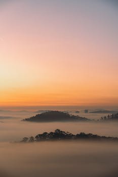 Breathtaking sunrise over misty hills in Đà Lạt, showcasing nature's serene beauty.