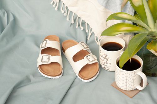 Free Flat lay scene with white sandals, coffee mugs, and a plant, perfect for summer relaxation. Stock Photo