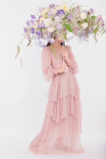 Artistic portrait of woman in pink dress with floral umbrella. Perfect for fashion concepts.