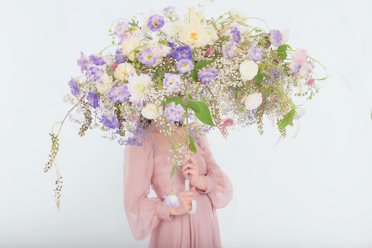 a person obscured by an abundant floral headpiece blending elegance an