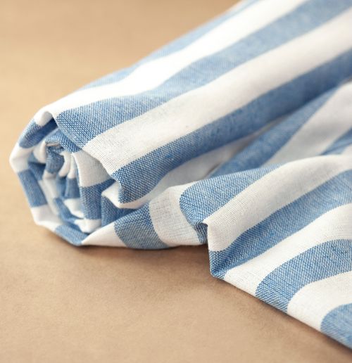 Rolled blue and white striped towel on sand — photo by Karen Laårk Boshoff on Pexels