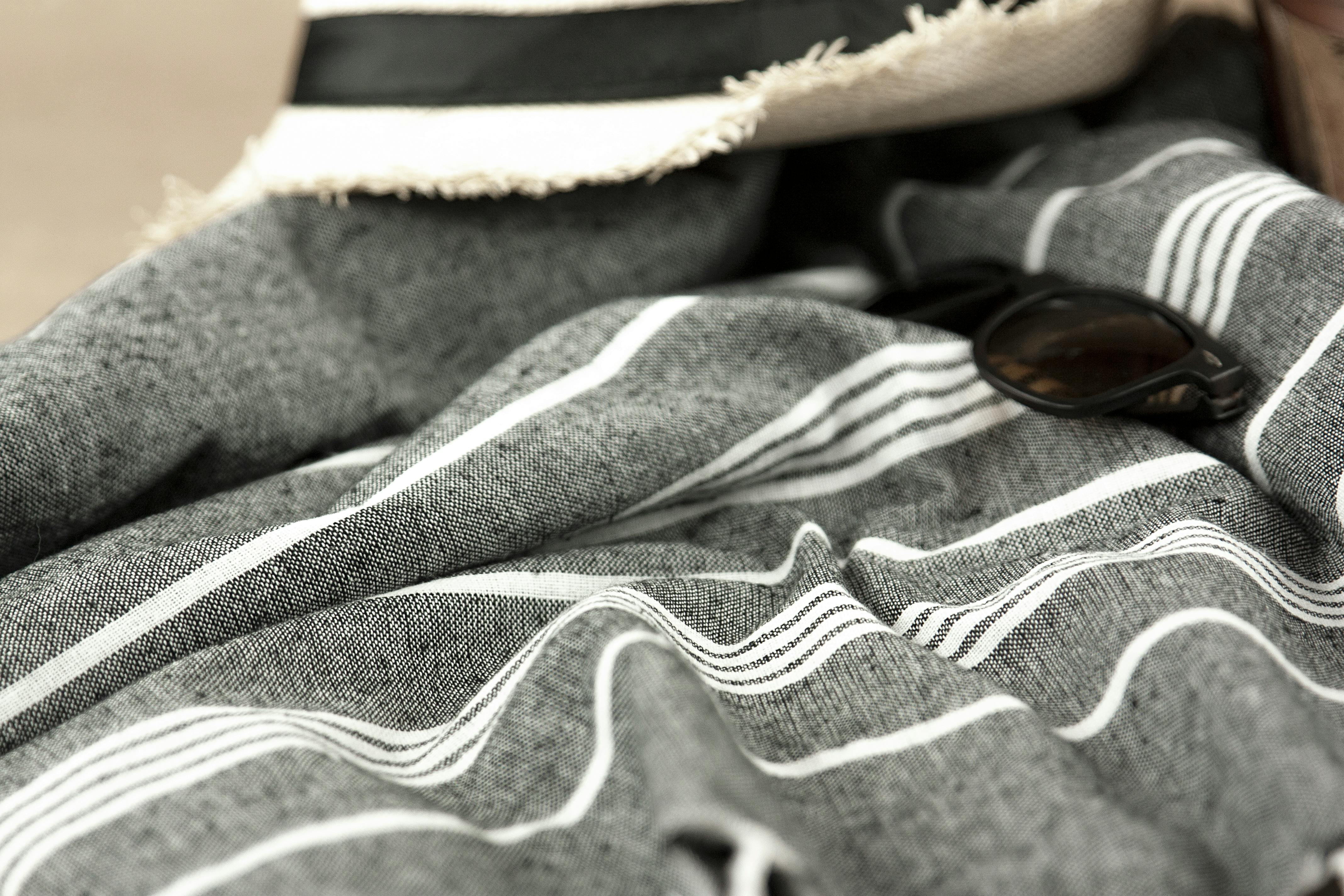 beach essentials with striped towel and sunglasses