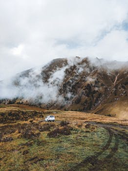 A car parked on a misty mountain valley in Steinach am Brenner, Tyrol, Austria.