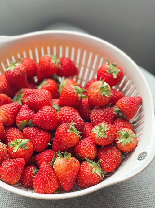 Free A vibrant collection of fresh strawberries in a white colander, ready to enjoy. Stock Photo