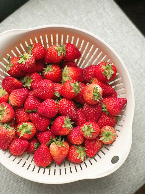 Free Vibrant ripe strawberries in a white colander, perfect for fruit themes. Stock Photo