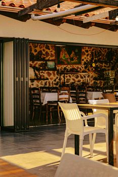 Charming outdoor seating of a rustic restaurant bathed in golden sunset light, inviting ambiance.