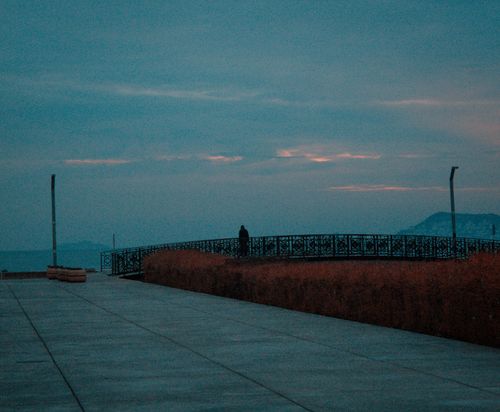 Free A serene twilight scene at İstanbul waterfront with a lone figure on the pier. Stock Photo