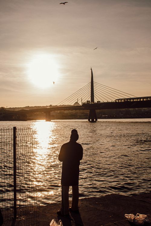 Free Silhouette of a person by the Golden Horn Bridge in Istanbul at sunset. Stock Photo