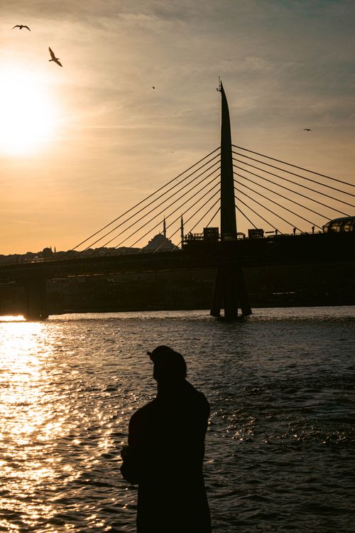 Free Silhouette of a person by the Haliç Metro Bridge during sunset in Istanbul, Turkey. Stock Photo