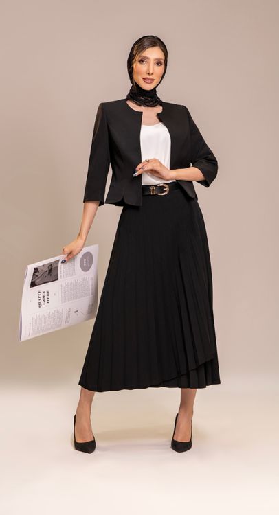 Woman wearing a pleated skirt with a knit top at the office