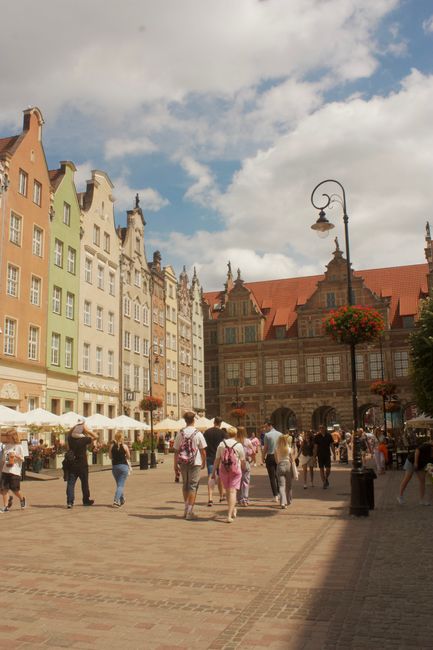 Bustling European square with historic buildings under a bright sky.