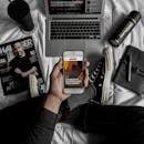 俯视时尚工作区，可见笔记本电脑、智能手机、杂志和个人用品