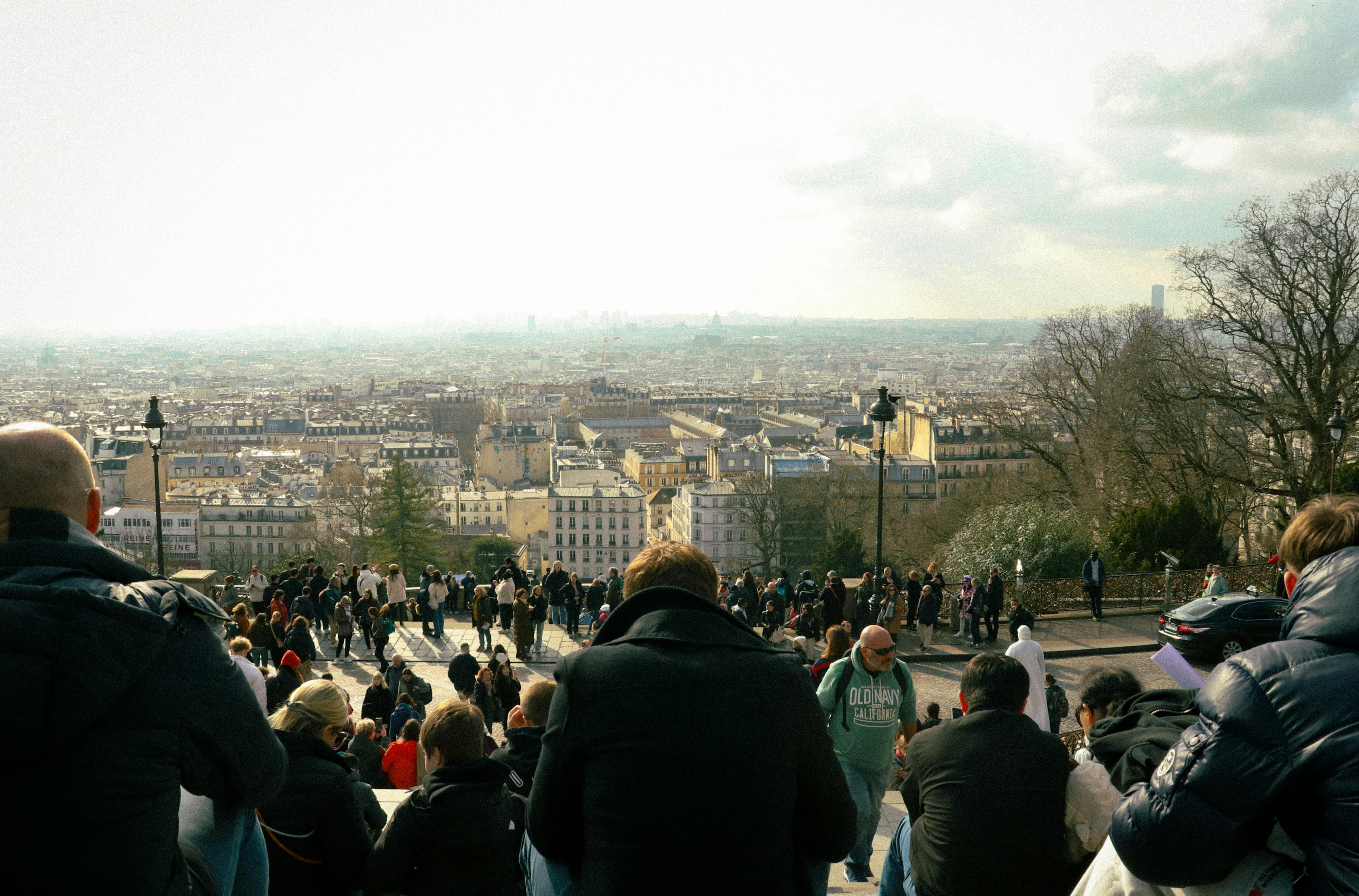 A vibrant scene of people enjoying the panoramic view of Paris from Montmartre, France.