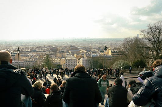 A vibrant scene of people enjoying the panoramic view of Paris from Montmartre, France.