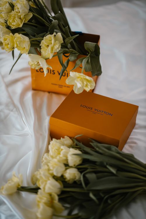 Free Yellow tulips artfully arranged with a luxury gift box on silky fabric, perfect for special occasions. Stock Photo