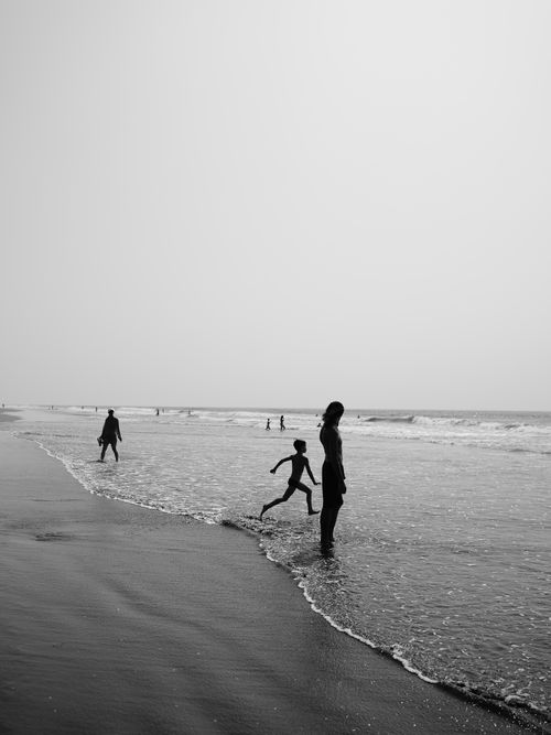 Free Serene black and white photo of people enjoying a quiet day at a beach in Goa, India. Stock Photo