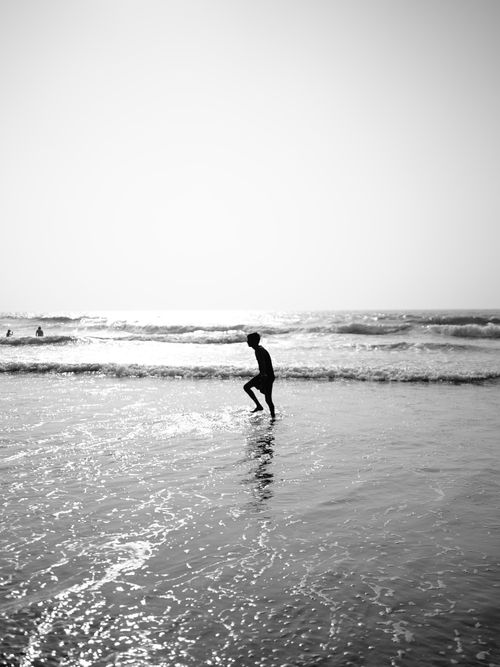 Free Artistic silhouette of a person dancing in the sea at Goa beach, India. Stock Photo