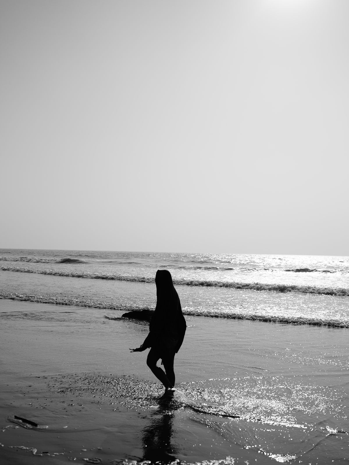 Silhouette of Woman Strolling by the Beach at Sunset · Free Stock Photo
