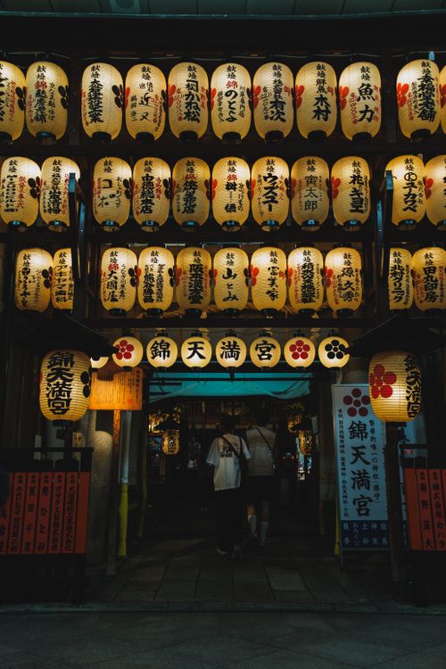 Free Entrance decorated with illuminated Japanese lanterns at night, creating a warm and cultural ambiance. Stock Photo