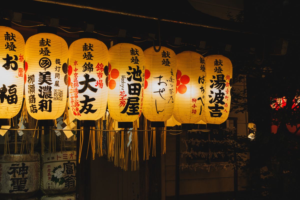 Glowing traditional Japanese festival lanterns lit against the dark sky — the kiriko lantern tradition of Noto Peninsula's summer festivals