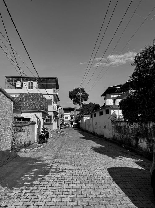 Free Serene black and white scene of a residential street with buildings and clear sky. Stock Photo
