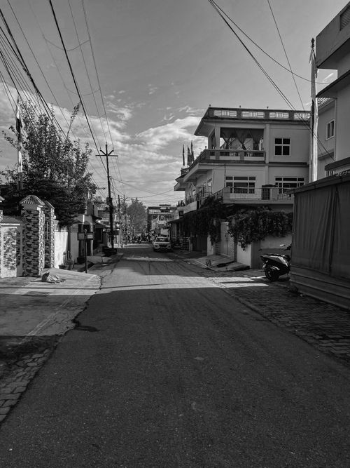 Free Peaceful black and white view of an empty urban street with buildings and sky. Stock Photo