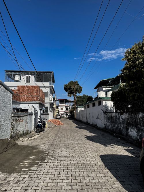 Free A peaceful residential street under a bright blue sky, capturing urban serenity. Stock Photo