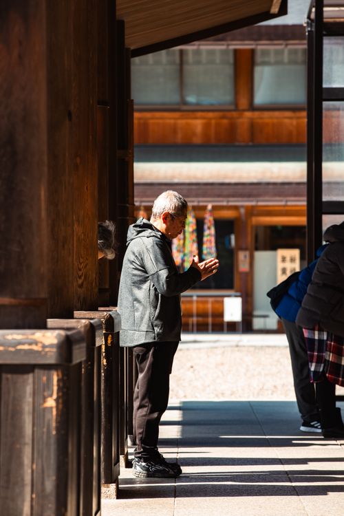 Free An elderly man praying at the historic Izumo Shrine, capturing a serene moment in Shimane, Japan. Stock Photo