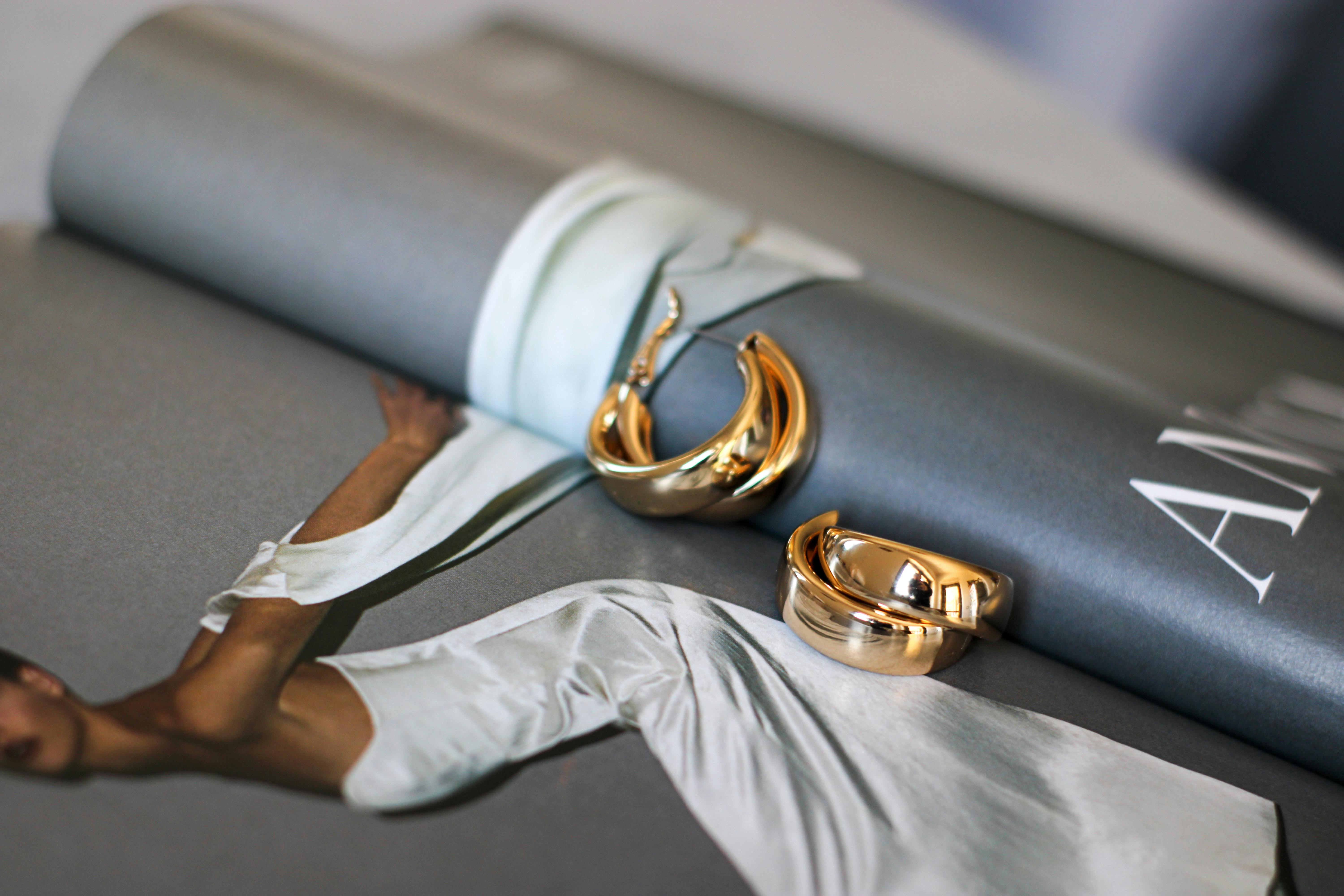 Luxurious gold jewelry displayed on a fashion magazine, showcasing style and elegance.