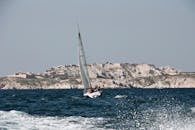 一艘帆船在布满历史建筑的岩石海岸线附近静静航行