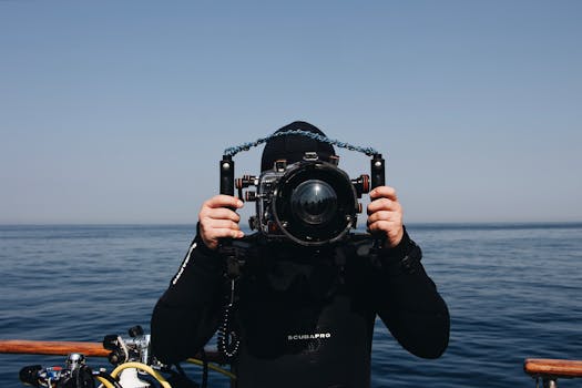 一名水肺潜水员在船边拿着水下相机装置
