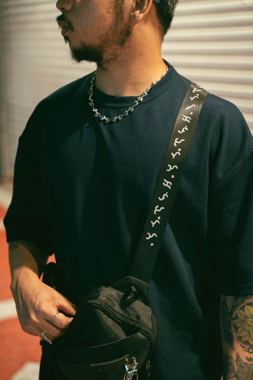 Free Stylish man with chain necklace and tattoo sporting street fashion bag. Stock Photo