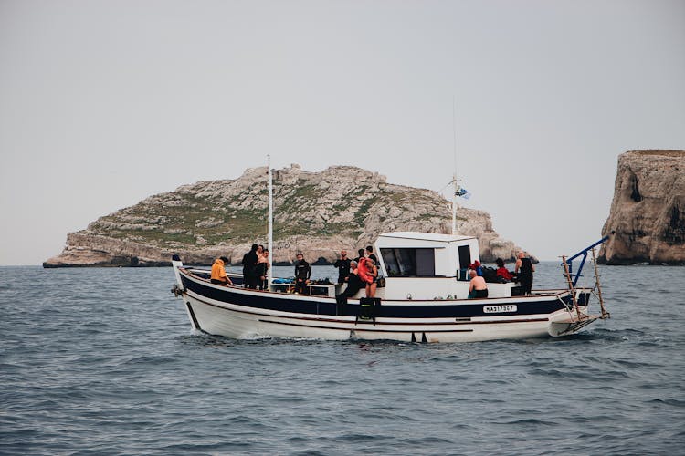 People Riding Boat Near Cliffs