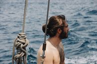 一名男子航行时眺望大海，看到了绳索和海浪