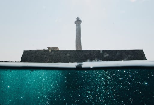 雄伟的灯塔矗立在平静的海面上，气氛宁静