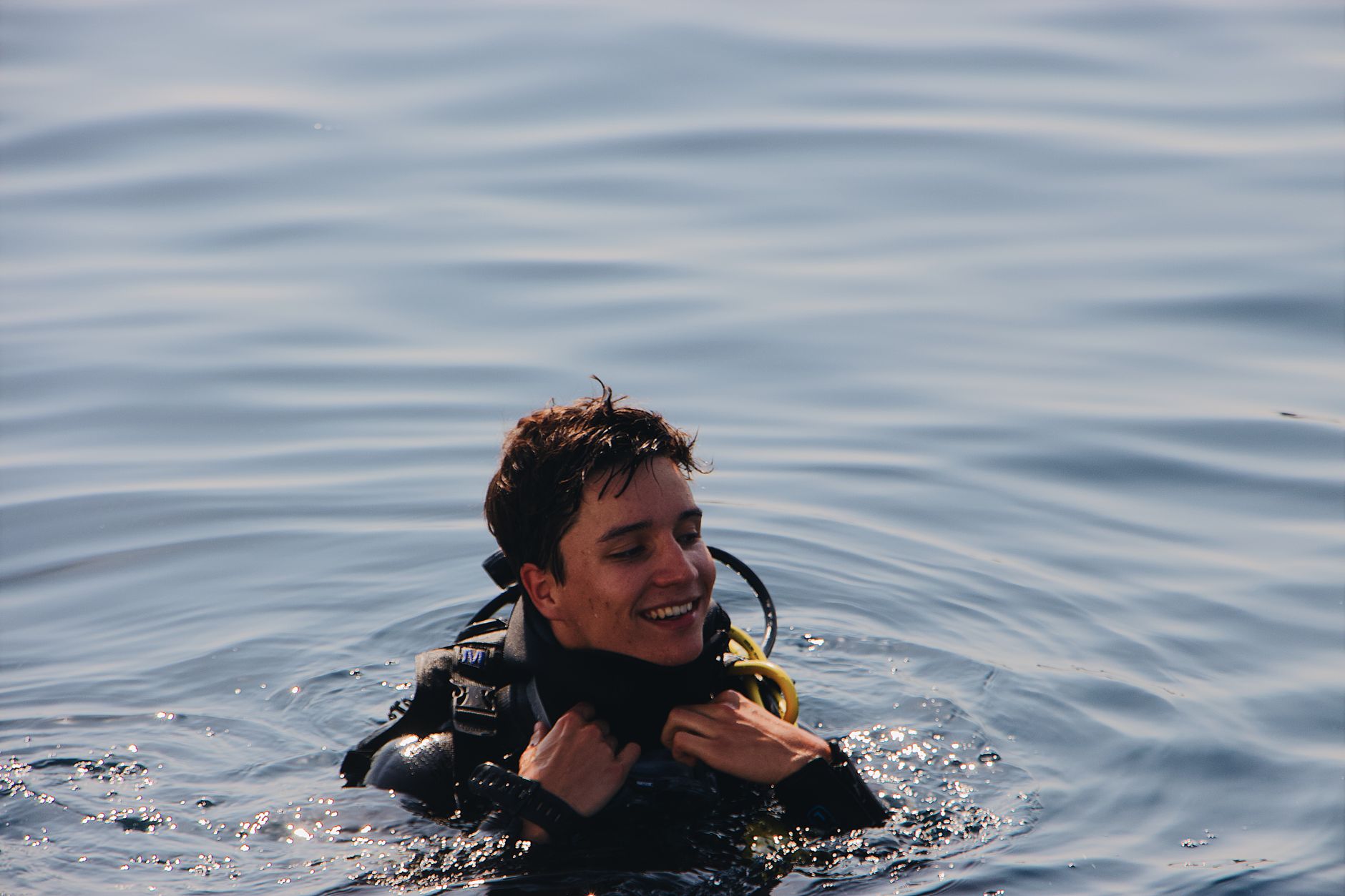 A joyful scuba diver enjoying a refreshing swim in the calm ocean water.