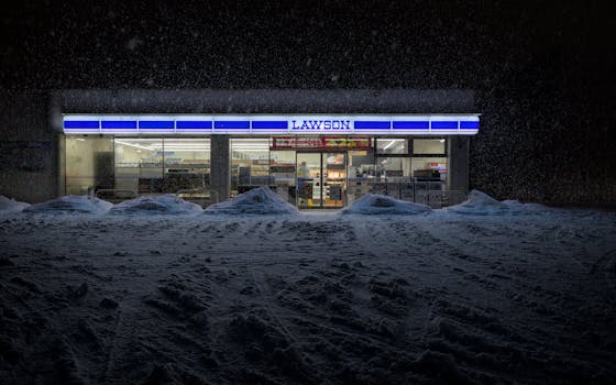Eiheiji Lawson store illuminated against winter snowfall, capturing serene urban night scene.