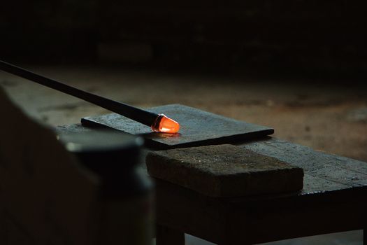 Glassblowing pipe in dark workshop