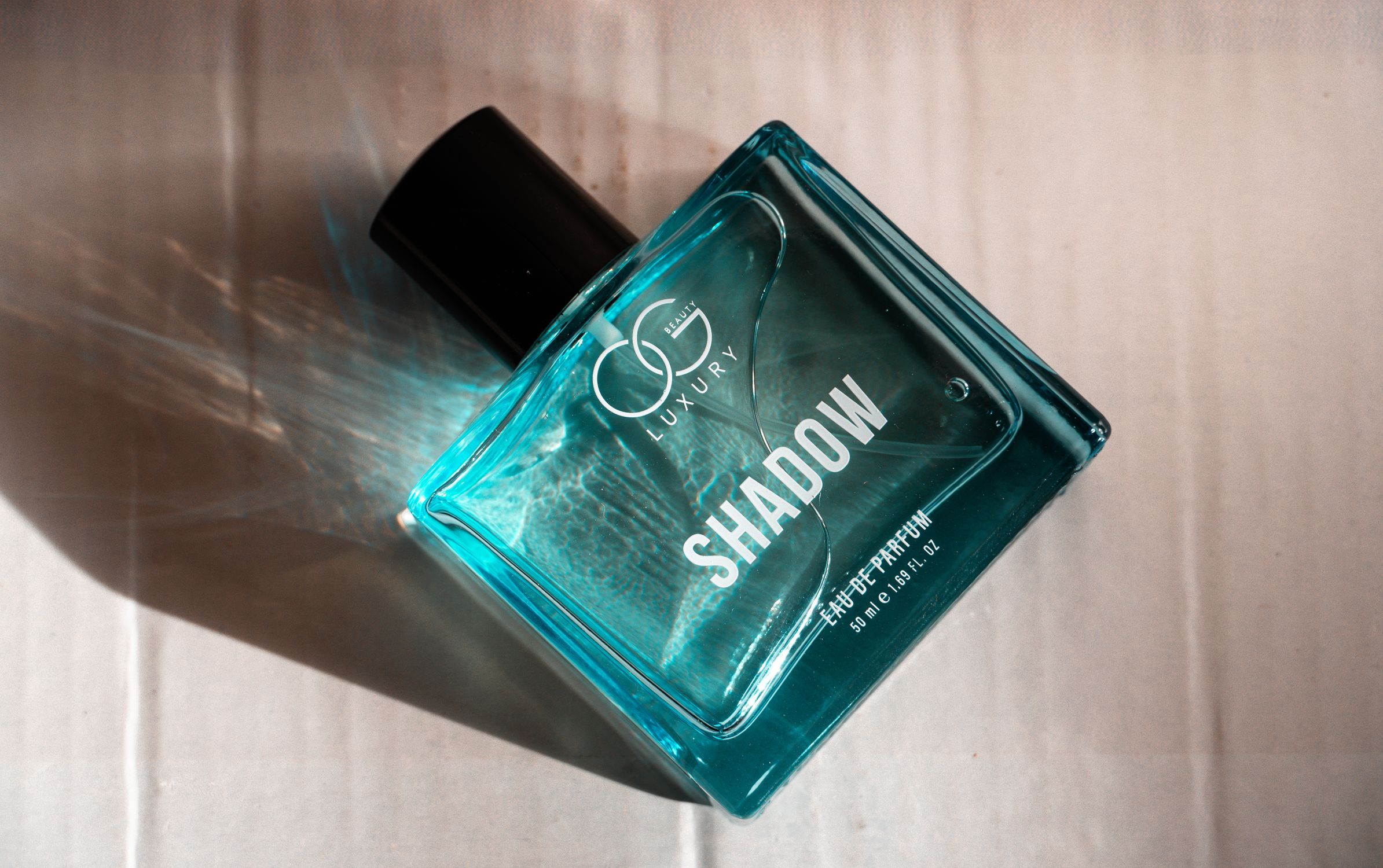 Shadow Cologne Elegant Shadow Perfume Bottle on Textured Surface · Free Stock Photo