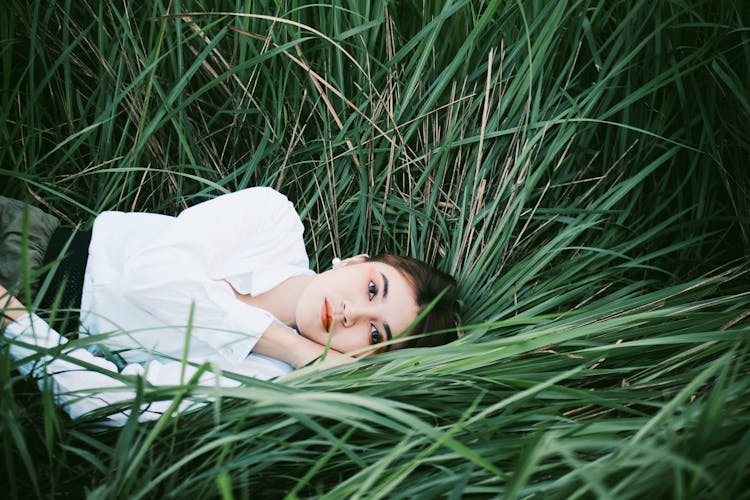 Woman Lying Down On Blades Of Grass