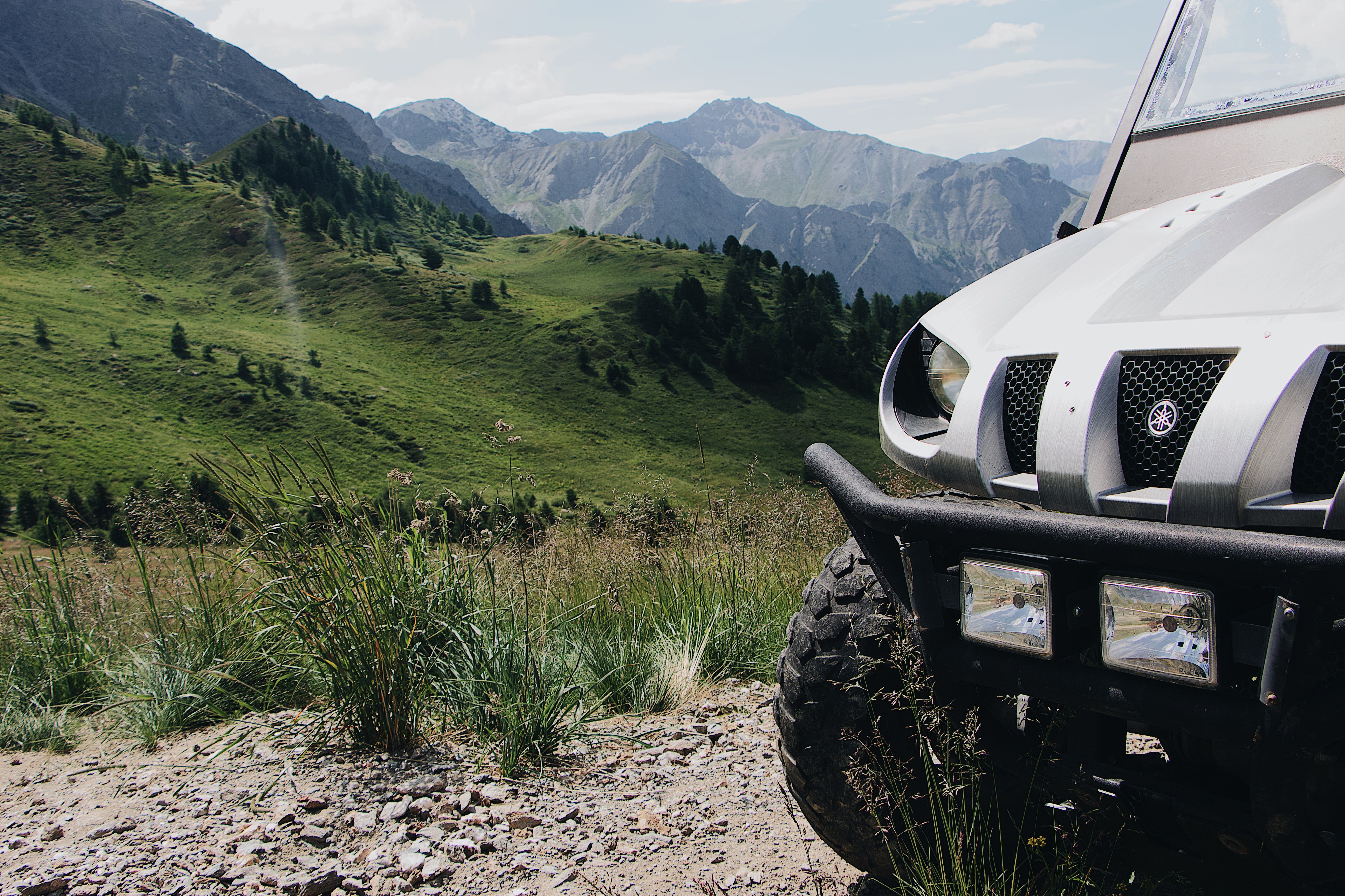 Explore the lush mountainous terrain with an off-road vehicle amidst stunning green scenery.