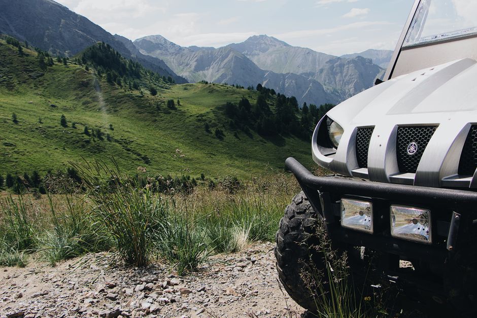 Explore the lush mountainous terrain with an off-road vehicle amidst stunning green scenery.